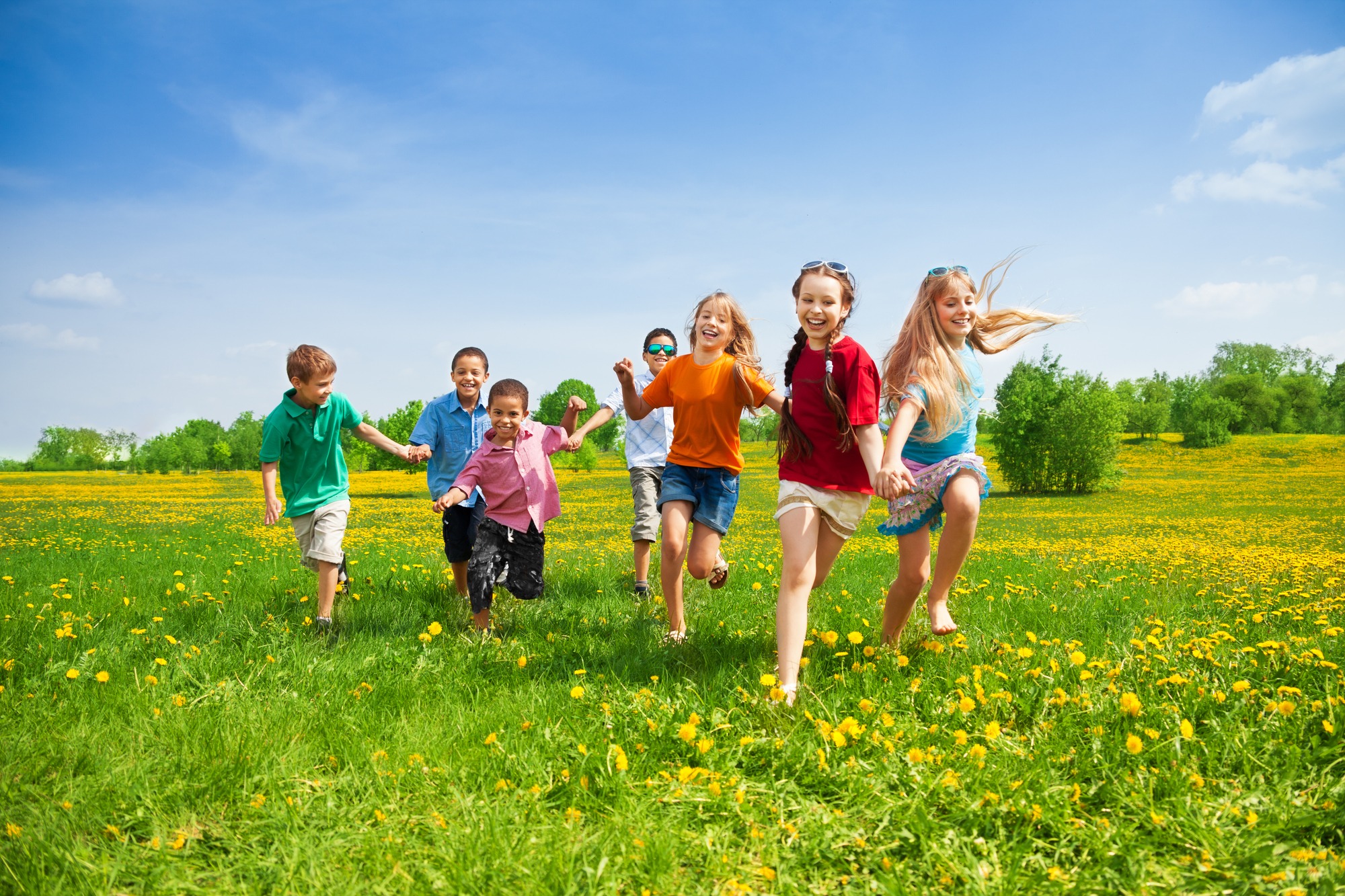 Kids running in the dandelion spring field